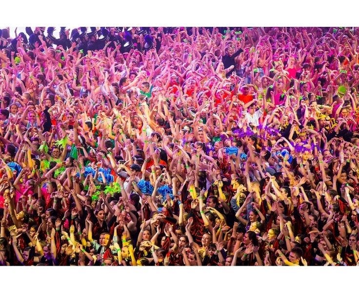 Hundreds of students from multiple schools in a group with thier hands up in the air at Southern Stars in Wollongong